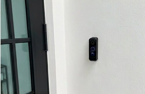 Video doorbell entry unit installed beside a glass entry door at a Miami property