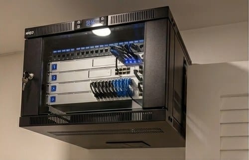 Wall-mounted network rack with a labelled patch panel and neatly dressed Cat6 cable runs