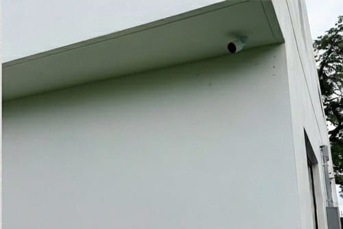 Bullet security camera mounted under a soffit on a South Florida property, installed with concealed cabling by 2TechNetwork